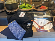 屋台カウンターに展示されている屋台刑事公式ファンボックスのTシャツ、リストバンド、ラーメン丼セット