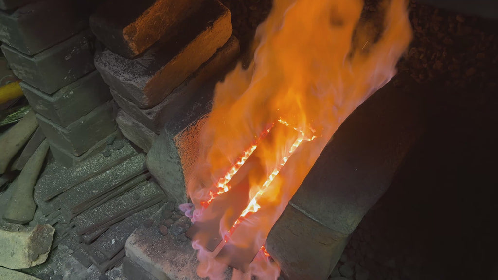A metal bar being heated and hammered to form a knife blade in the Takeshi Saji Knives workshop