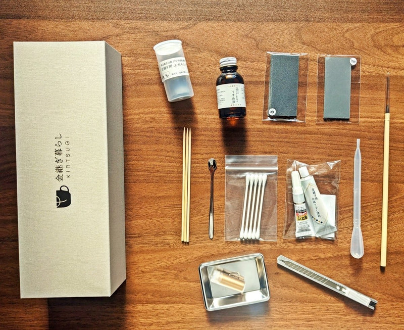 Parts included in Kintsugi Repair Kit by Kintsugi Kurashi displayed on wooden background with box