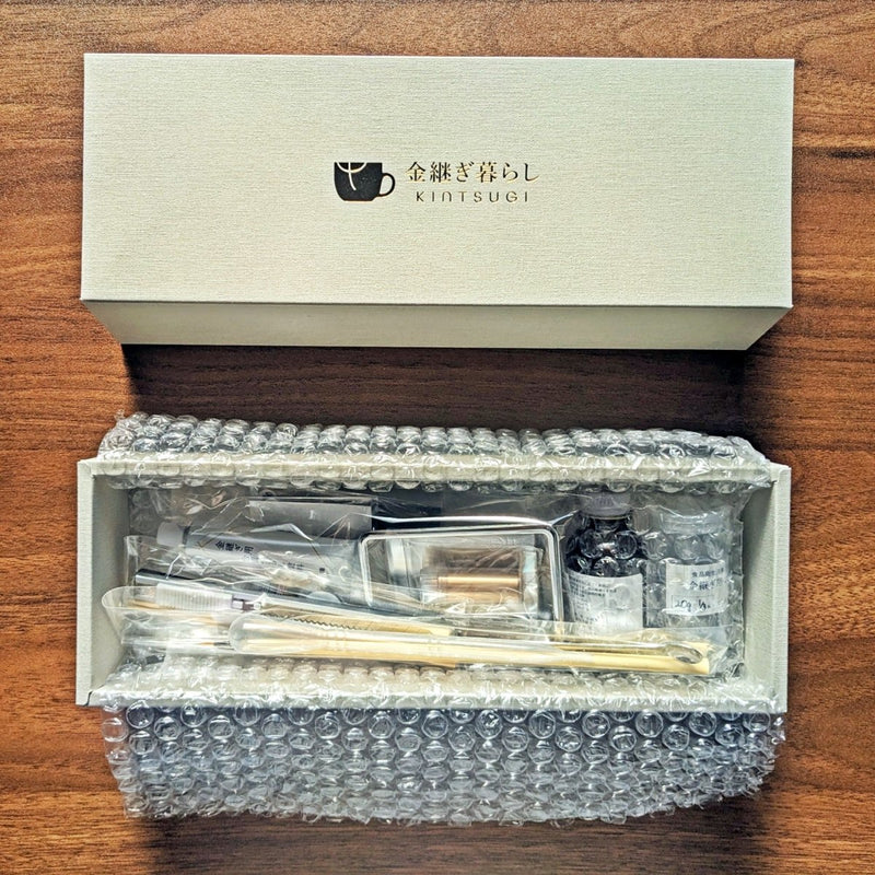 Kintsugi Repair Kit by Kintsugi Kurashi in box next to lid on wooden background