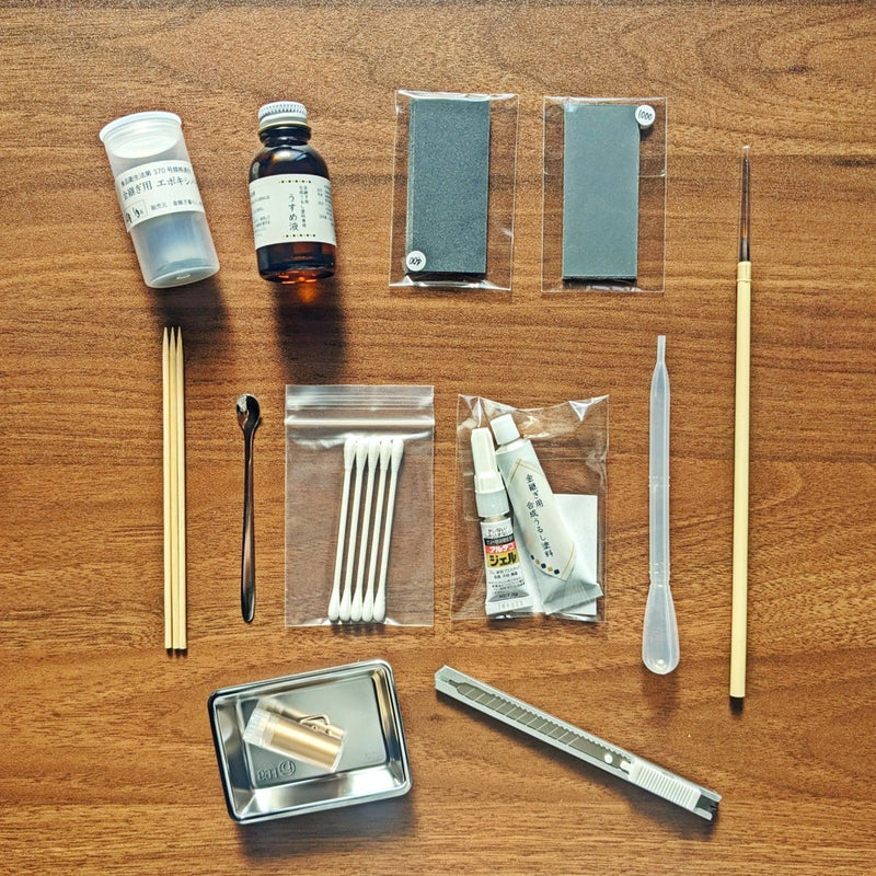 Parts included in Kintsugi Repair Kit by Kintsugi Kurashi displayed on wooden background without box