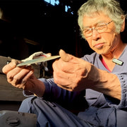 Shirou Kunimitsu craftsman examining knife in his workshop