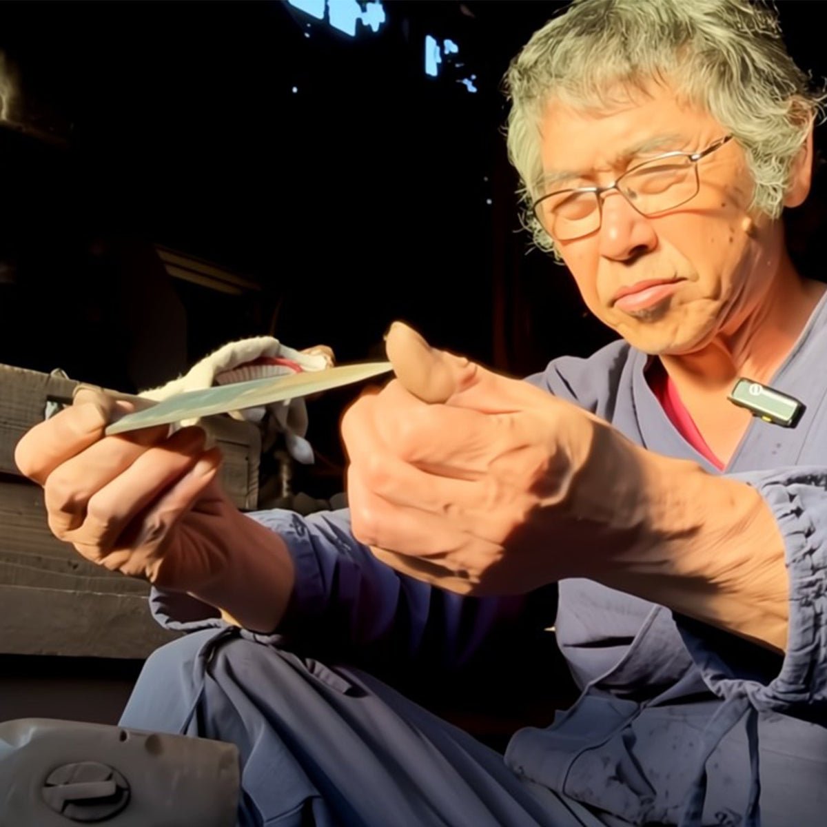 Shirou Kunimitsu craftsman examining knife in his workshop