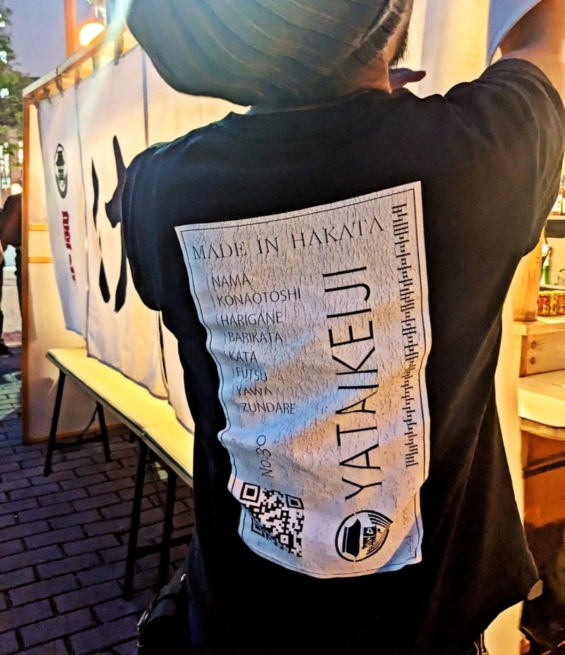 屋台刑事の公式Tシャツを着て屋台の準備をする安倍さんの後ろ姿のアップ