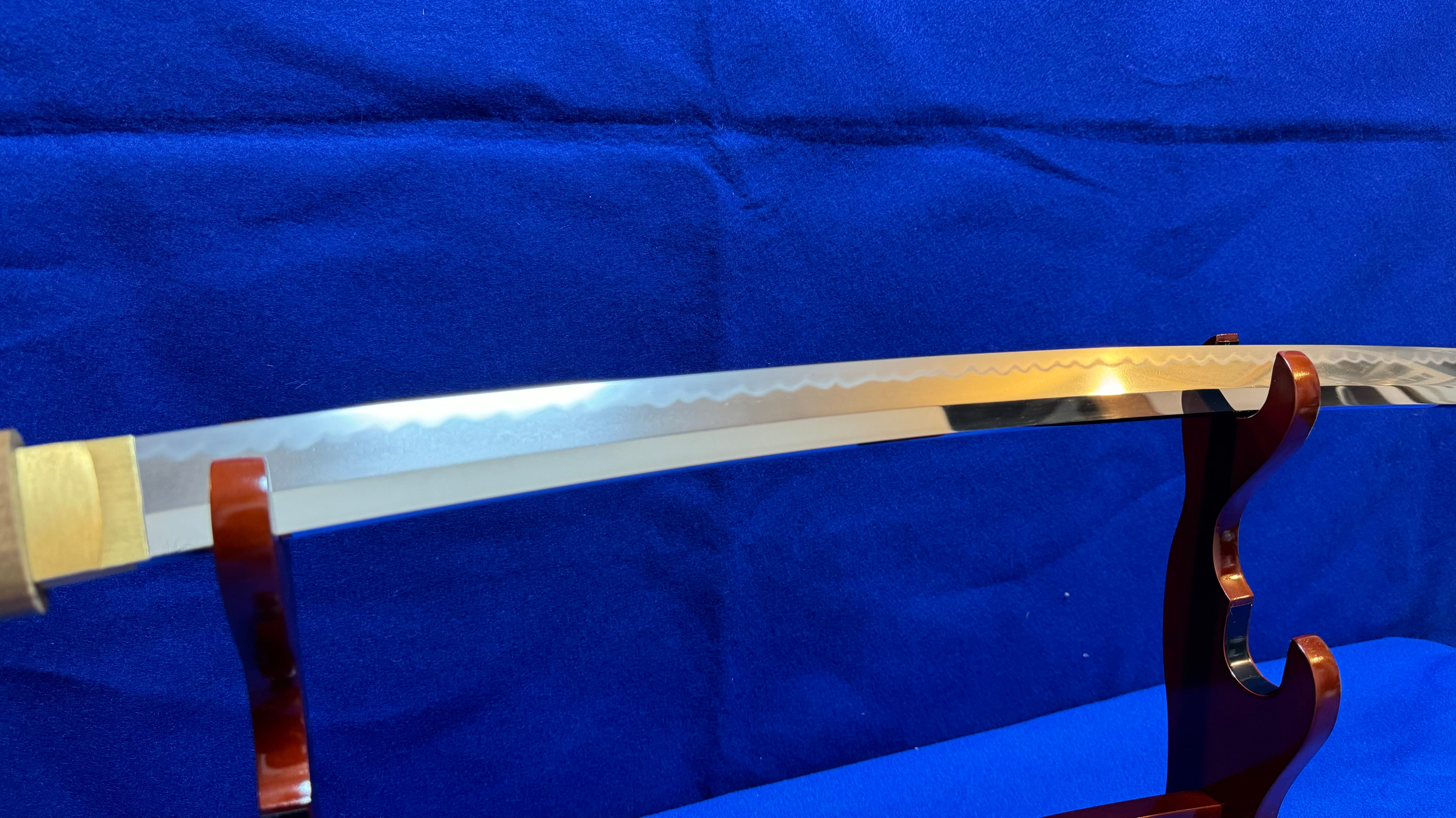 zoomed in photo of a Katana blade, with blue background